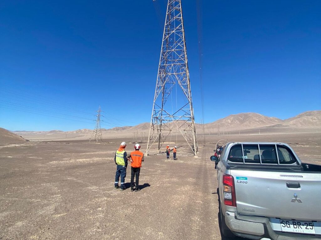 Equipo de Rayenco en terreno junto a torre de línea de transmisión